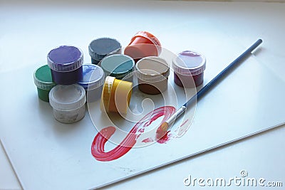 Ten colors in paint cans and one brush Stock Photo