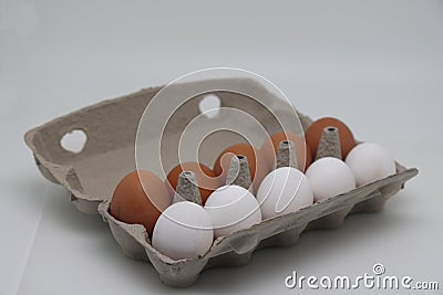 Ten eggs in a carton. A dozen raw white and brown eggs. Stock Photo
