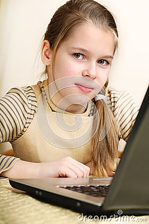 Ten years' girl works on a laptop, Stock Photo