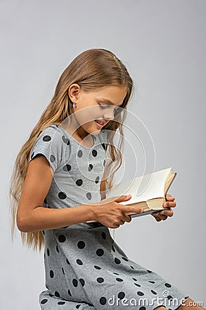 A ten years old girl enjoys reading a book Stock Photo