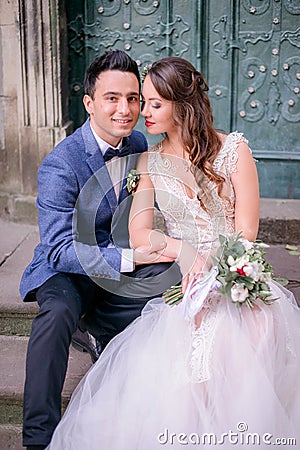 Tender bride lies her hand over groom`s knee Stock Photo