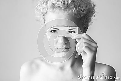 Tender curly-haired girl closes her eyes to picture painted eyes. Stock Photo