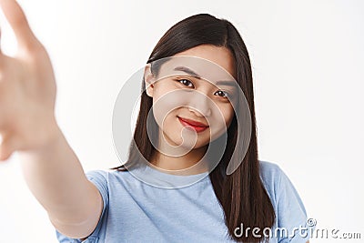 Tender cute happy brunette asian girl record video message extend arm forward hold camera smartphone smiling broadly Stock Photo