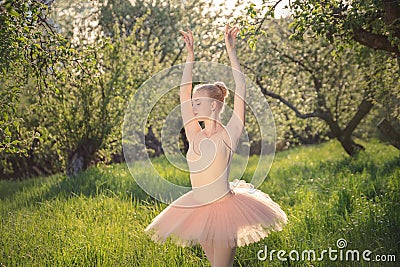 Tender dancer woman in green flowers landscape at sunset Stock Photo