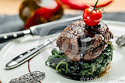 Tender lean medium rare beef fillet steak medallions with one sliced through to show the red meat with spinach, Restaurant menu, Stock Photo