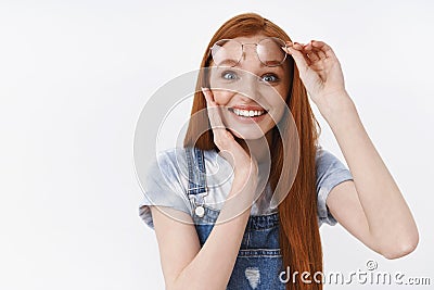 Tender pleased and surprised cute blue-eyed ginger girl smiling toothy amazed, touch cheek delighted satisfied, take-off Stock Photo