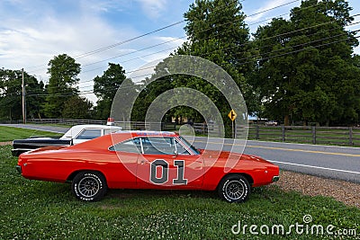 Replicas of the General Lee Charger and the Sheriff car, from the television series The Dukes of Hazzard, parked along a country r Editorial Stock Photo