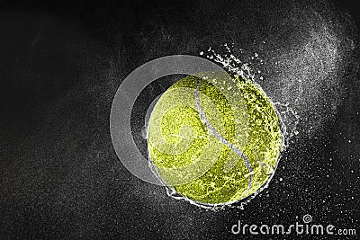 Tennis ball flying in water drops and splashes isolated on black background Stock Photo