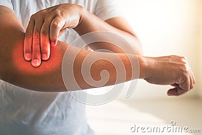 Tennis elbow concept. The man uses fingers to massage his arm. Healthcare knowledge. Medium close up shot Stock Photo
