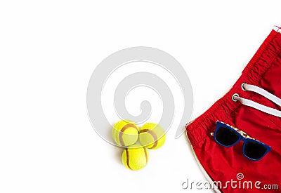 Tennis game concept. Sport objects on white. Sunglasses, shorts and tennis balls on white background Stock Photo