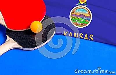 Tennis rackets and ball with flag Kansas on blue background, flag mockup. Table tennis competition concept Stock Photo