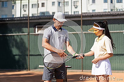 Tennis training. Professional coach learning woman how to play. Tennis trainer showing sports woman correct position on Stock Photo