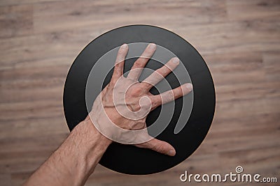 Tense thin male palm with veins on a black circle Stock Photo