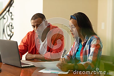 Tensed african american couple planning budget through financial bills and laptop at home Stock Photo