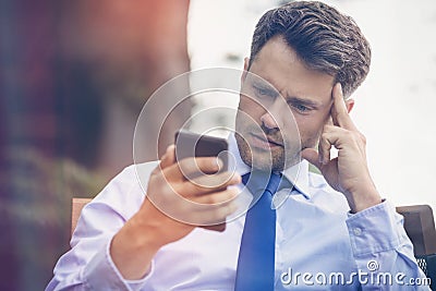 Tensed businessman using mobile phone Stock Photo