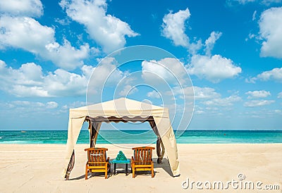 Tent with two sun beds, a table and towels on a sandy beach Stock Photo