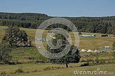 Tents of a scouts camp in a meadow in the hills of Ardennes, Belgium Editorial Stock Photo