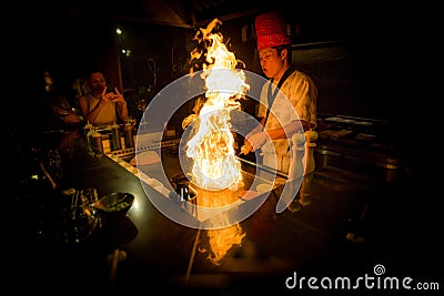 May, 2018 - Ari Atoll, Maldives: Happy teppanyaki chef cooking vegetables at teppan in a Japanese steakhouse on Mishi Sushi Editorial Stock Photo