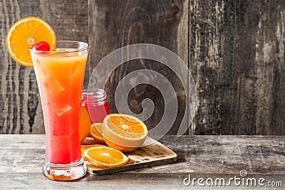 Tequila sunrise cocktail in glass on wooden table. Stock Photo