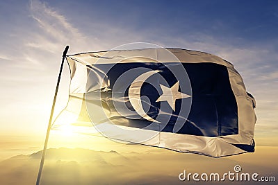 Terengganu state of Malaysia flag textile cloth fabric waving on the top sunrise mist fog Stock Photo