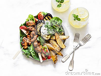 Teriyaki chicken skewers, roasted potatoes, vegetables, grilled eggplant and lemon mint cocktail - delicious appetizer plate, Stock Photo