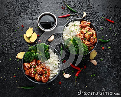 Teriyaki chicken, steamed broccoli and basmati rice served in two Asian clay bowls Stock Photo