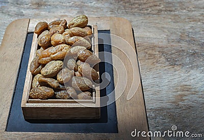 Terminalia bellerica or Terminalia chebula Organic dry harad. Dried fruits in the wooden box Stock Photo