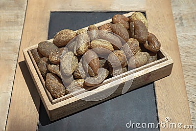 Terminalia bellerica or Terminalia chebula Organic dry harad. Dried fruits in the wooden box Stock Photo