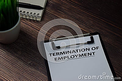 Termination of Employment write on paperwork isolated on wooden table Stock Photo