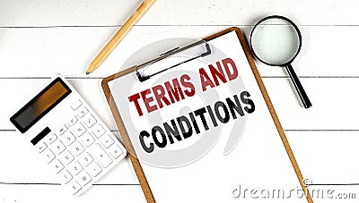 TERMS AND CONDITIONS words on clipboard, with calculator, magnifier and pencil on the white wooden background Stock Photo