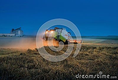 TERNOPIL REGION, UKRAINE - August 03, 2021: - CLAAS combine harvester works at night in a wheat field, evening lighting of reaping Editorial Stock Photo