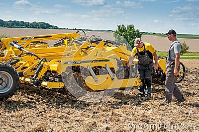 TERNOPIL REGION, UKRAINE - August 10, 2021: man inspect tractor cultivator on demonstration of agricultural machinery, exhibition Editorial Stock Photo