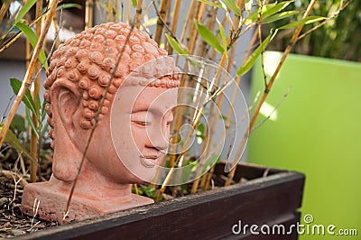 Terra cotta buddha and bamboo in the garden Stock Photo