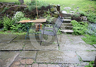 Terrace with garden furniture during heavy rain. Stock Photo