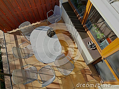 terrace by house.paving tiles brown and yellow. oval table, Stock Photo