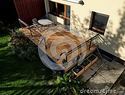 terrace by house.paving tiles brown and yellow. oval table, Stock Photo