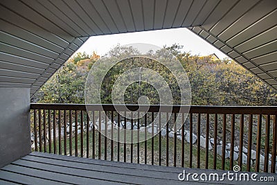 Terrace with a wood planks flooring and a beadboard white ceiling of a half hip roof Stock Photo