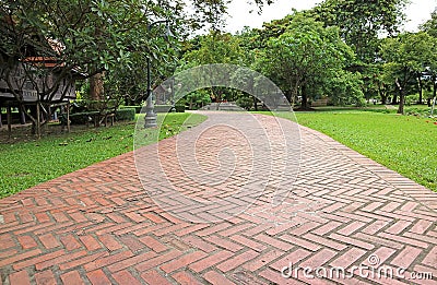 Terracotta Brick Paver Walkway in the Vibrant Green Garden in Thailand Stock Photo