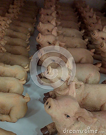 Terracotta piglets stowed in a row, cute little animals ready to be placed in the cribs at Christmas. Stock Photo