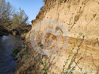 Terrain geology sedimentary layered rock and soil with little stream Stock Photo