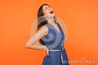 Terrible backache. Ill brunette woman holding lower back and screaming in pain, suffering injured spine disk Stock Photo