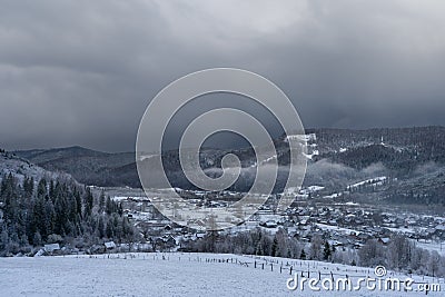 Terrible black sky before a snowfall. Beautiful landscape of a mountain winter village. Weather forecast Stock Photo