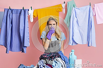 Housewife closes nose in front of heap of dirty clothes Stock Photo