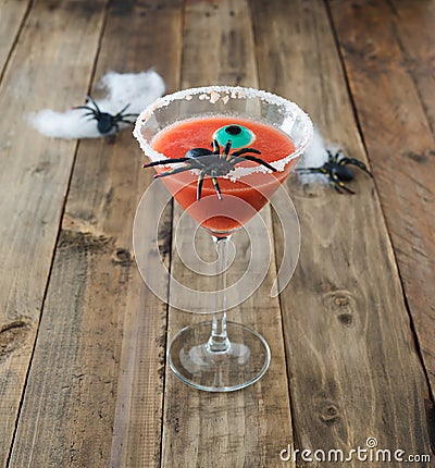 Terrifying red cocktail with spider on wooden background for Halloween with decoration. Photo square format Stock Photo