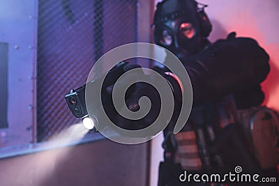 Terrorist with gas mask holding gun and aiming Stock Photo