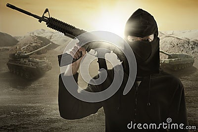 Terrorist with gun and military vehicle Stock Photo