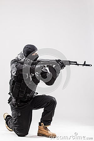Terrorist holding a machine gun in his hands aim isolated over white Stock Photo