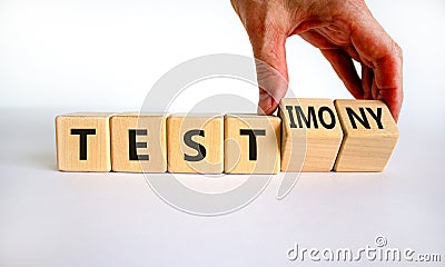 Test or testimony symbol. Businessman turns wooden cubes and changes the word `test` to `testimony`. Beautiful white backgroun Stock Photo