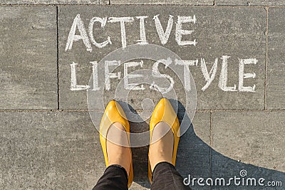 Text active lifestyle written on gray pavement with woman legs, view from above Stock Photo