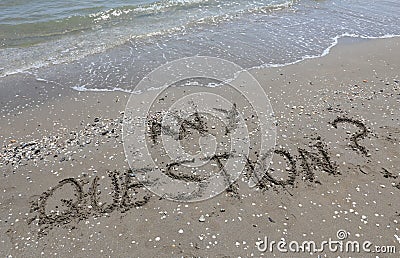 text any question written in the sand of the beach by the sea Stock Photo